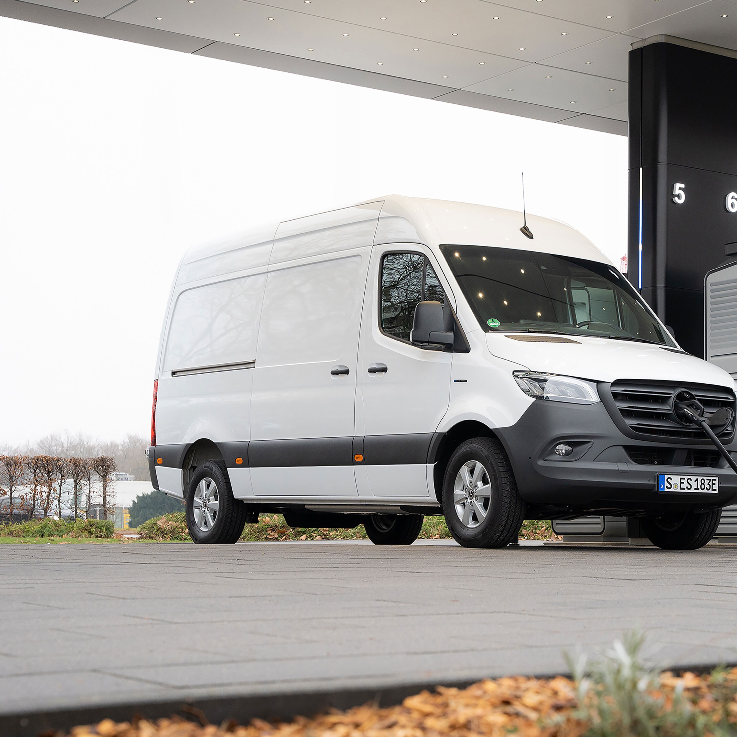Egy Mercedes-Benz kishaszongépjárművek egy töltőállomás előtt töltés közben.