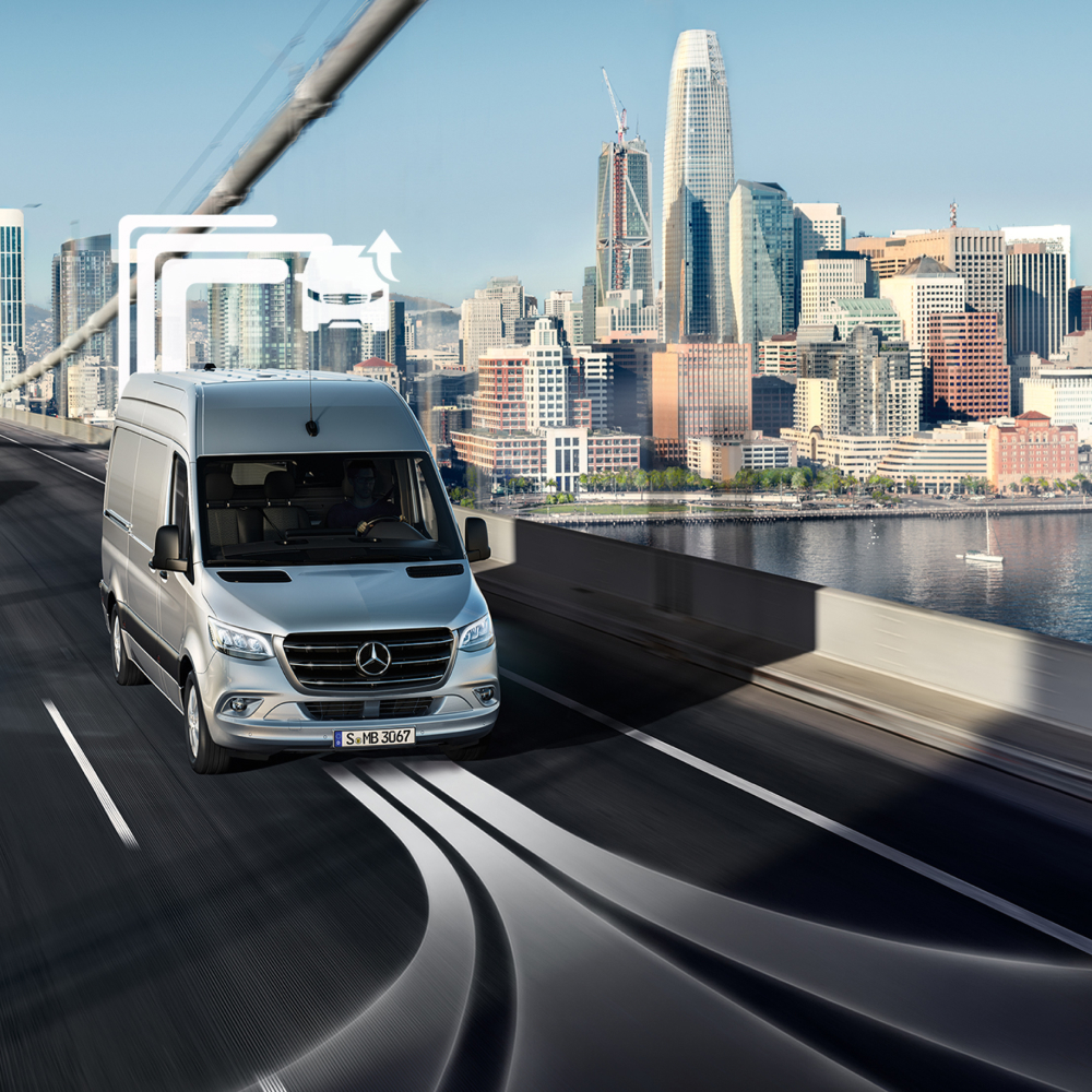 Van Uptime Monitor előnyök | Digitális extrafelszereltségek | Mercedes-Benz Egy Mercedes-Benz furgonszállító egy többsávos hídon halad át nappal.