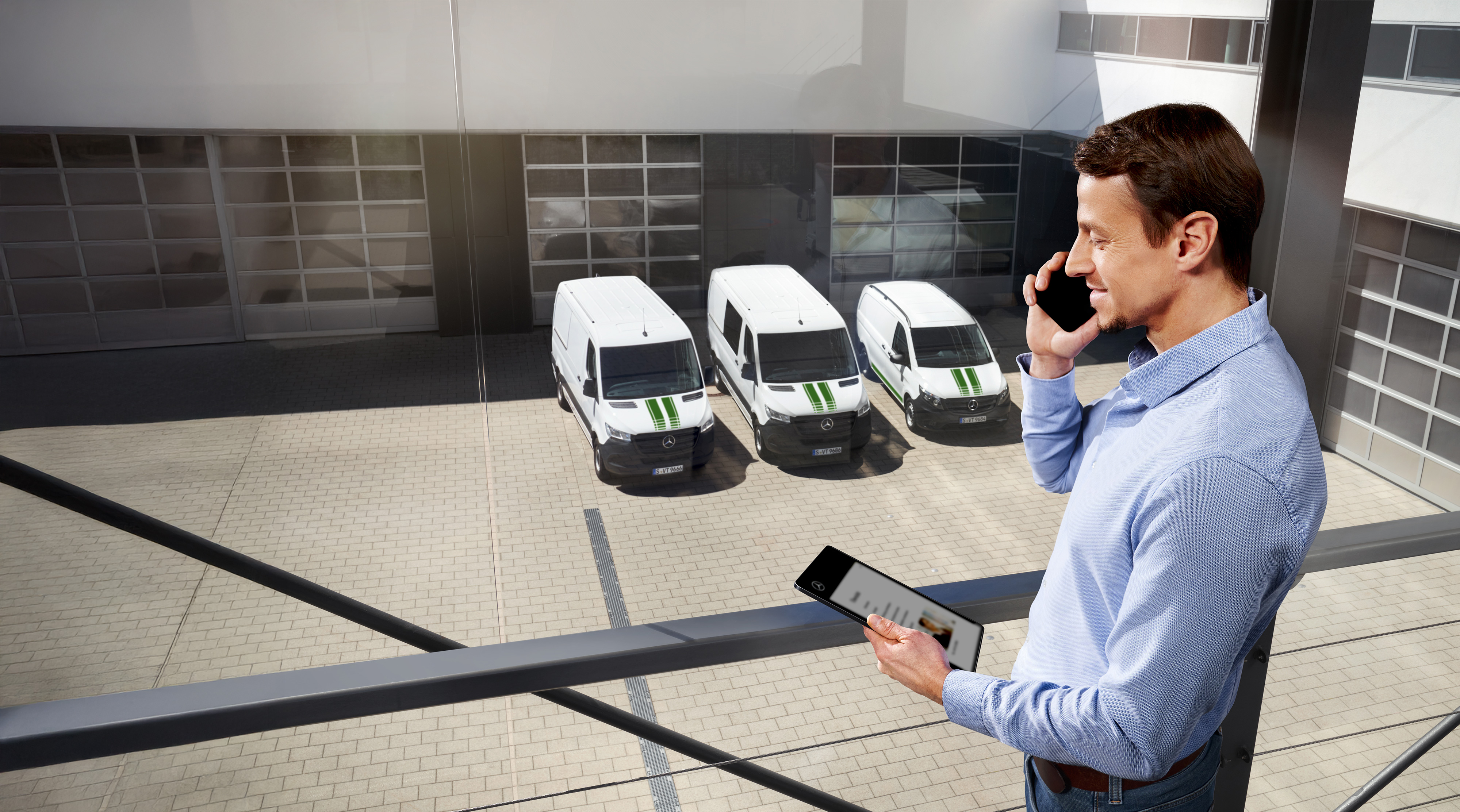 Mercedes-Benz | Kishaszongépjármű minőség Férfi tablettel és mobiltelefonnal három Mercedes-Benz kishaszongépjármű előtt.