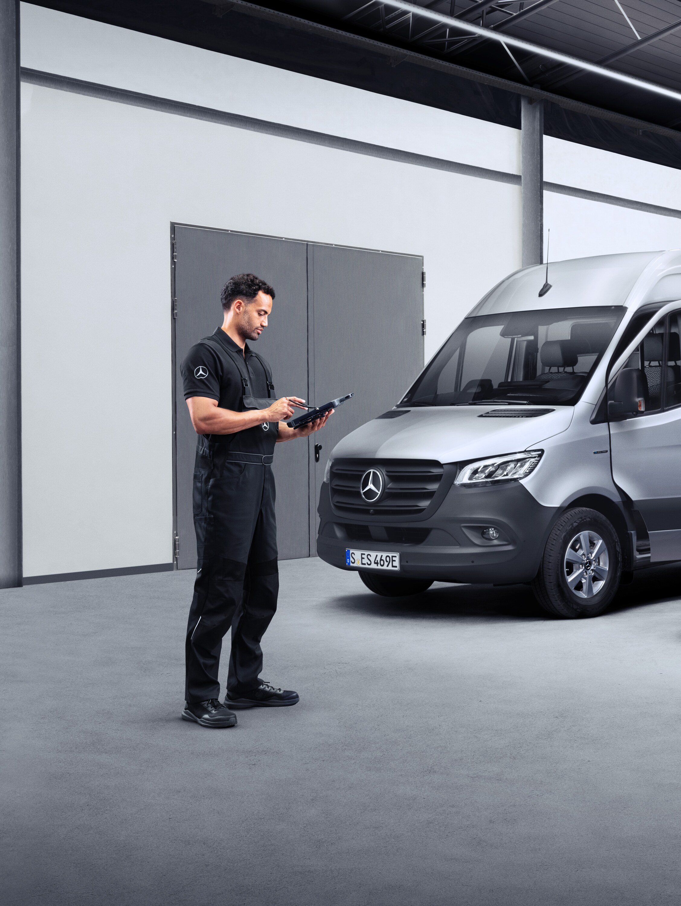 Egy technikus két elektromos kishaszongépjármű előtt egy tableten