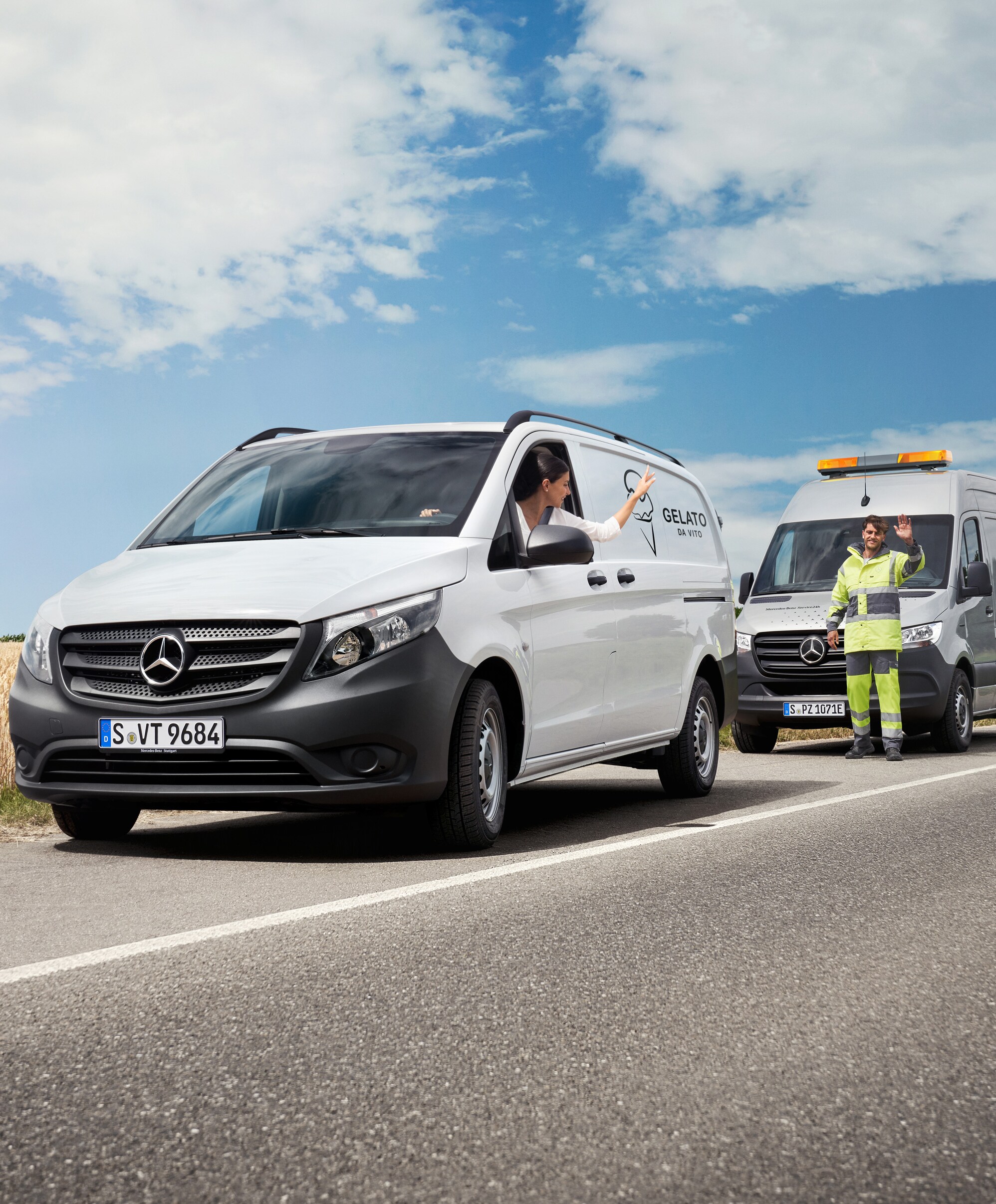 Egy technikus, aki egy fehér Mercedes-Benz Vito-ban ülő ügyfélnek nyújt műszaki segítséget.