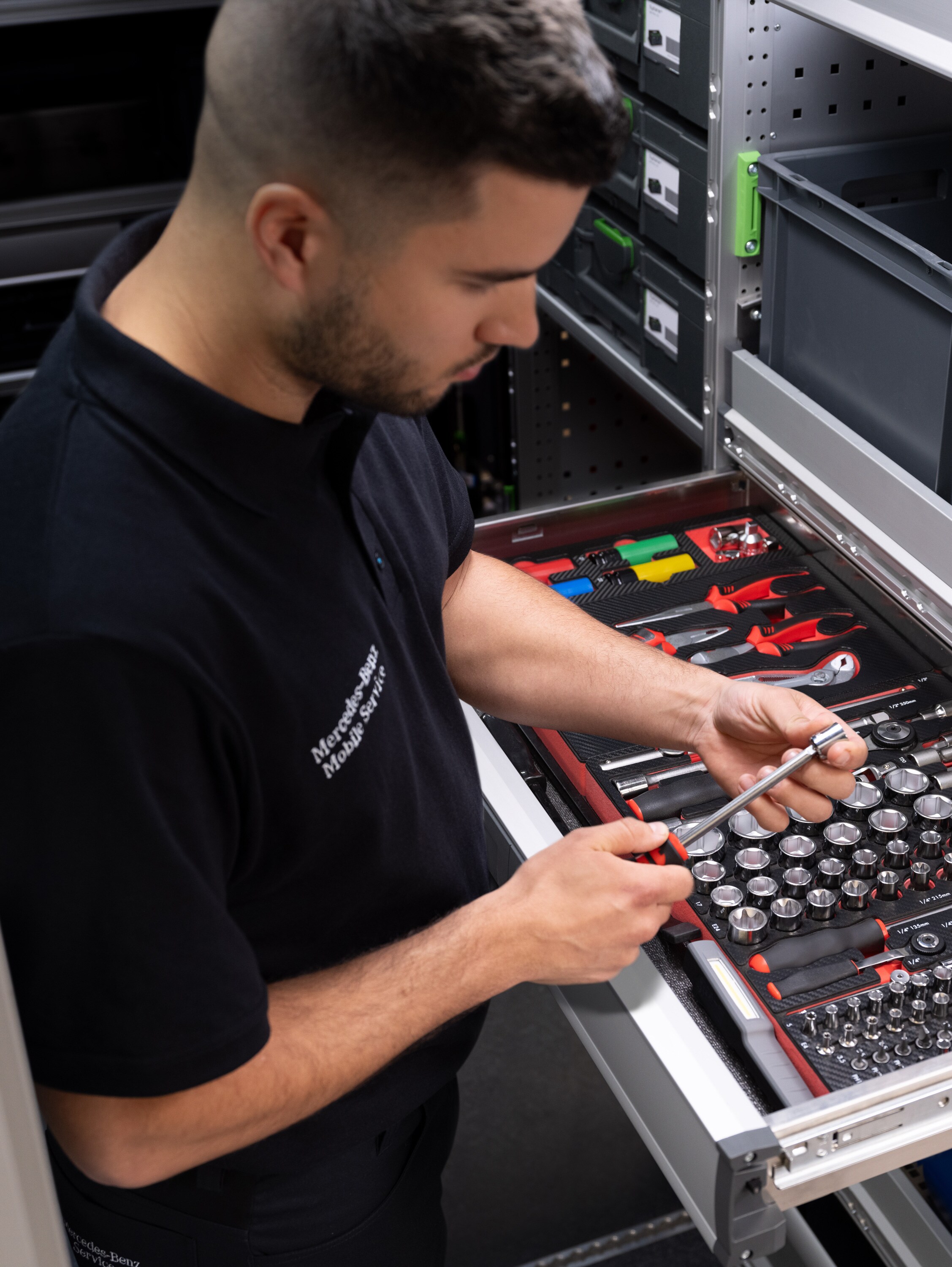 Egy technikus kiválaszt egy tárgyat a szerszámokkal teli fiókból.