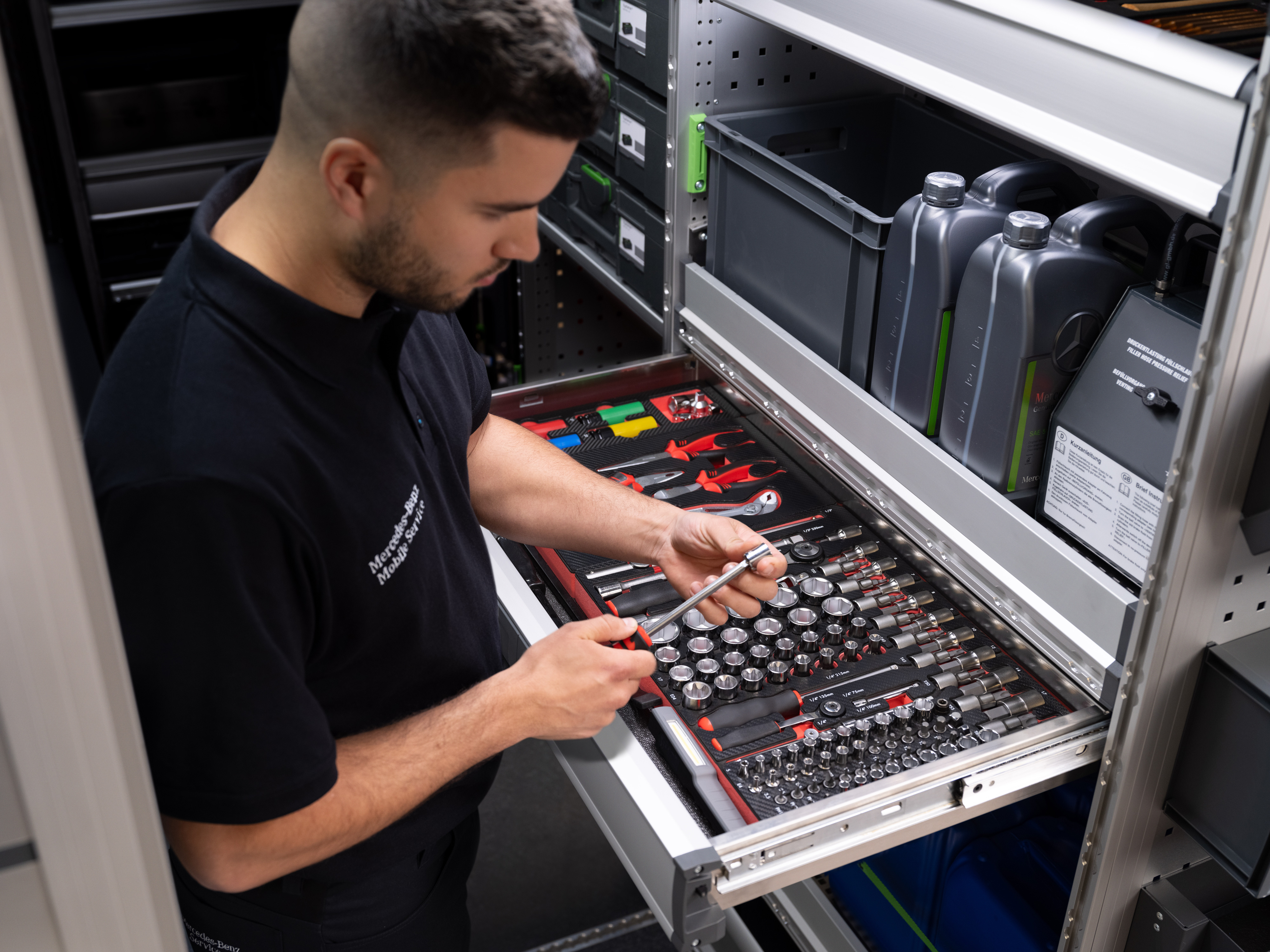 Mercedes-Benz | Mobile Service | Elektronika Egy technikus kiválaszt egy tárgyat a szerszámokkal teli fiókból.