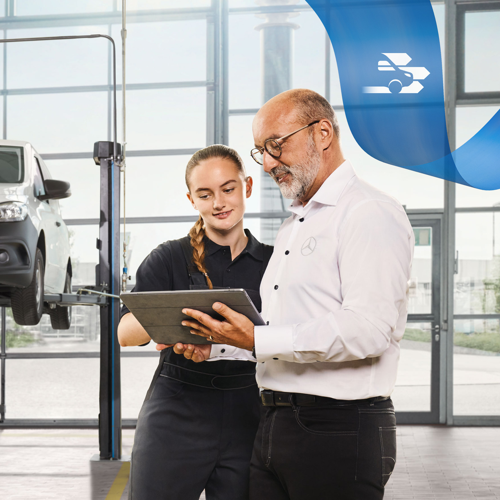 Mercedes-Benz | Karbantartás Két alkalmazott a műhelyben egy felemelt Mercedes-Benz kishaszongépjármű szervizeléséről beszélget.