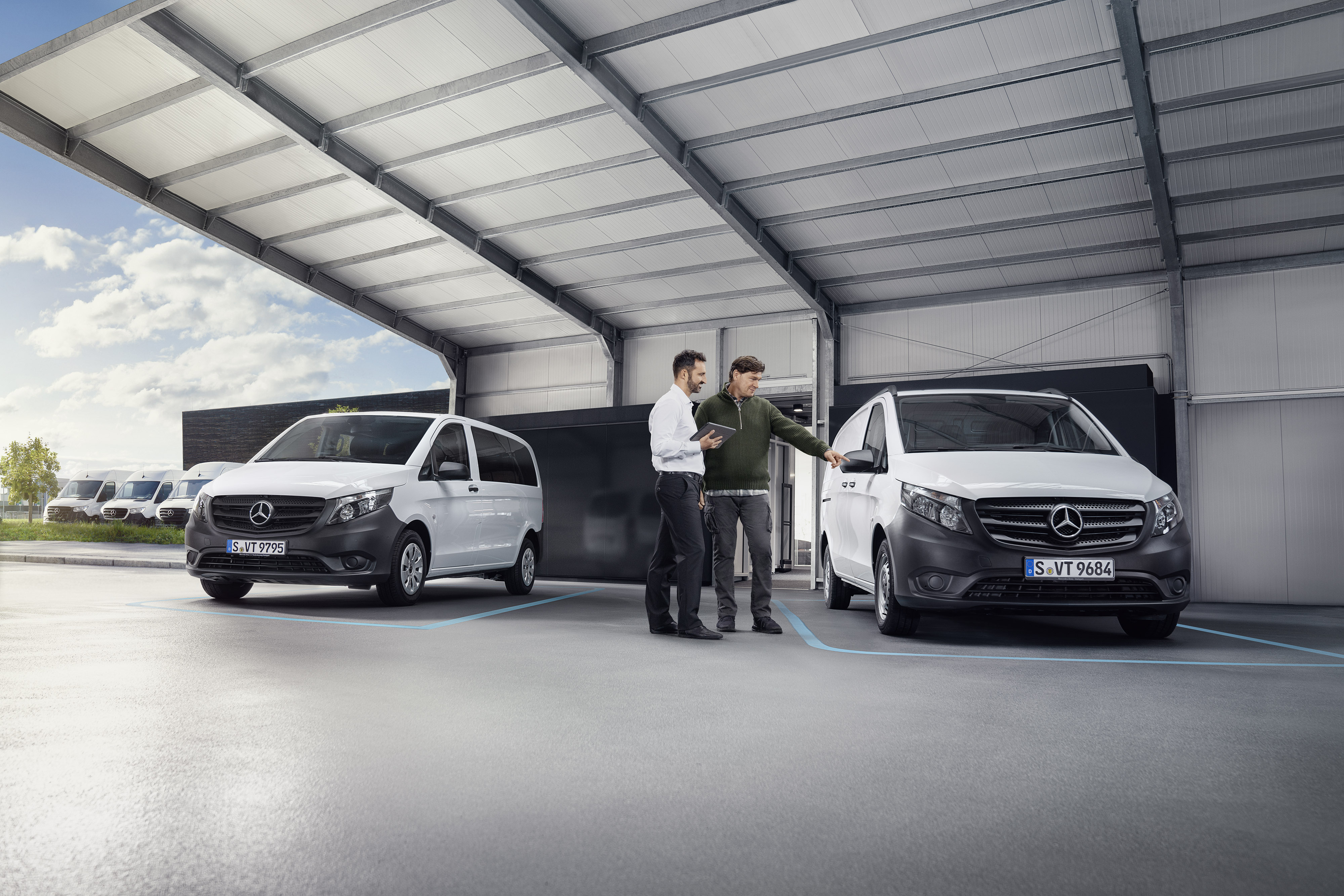 Mercedes-Benz | Visszahívás Mercedes-Benz ügyfélszolgálati ügyintéző az ügyféllel egy szervizpartnernél egy kishaszongépjármű előtt.