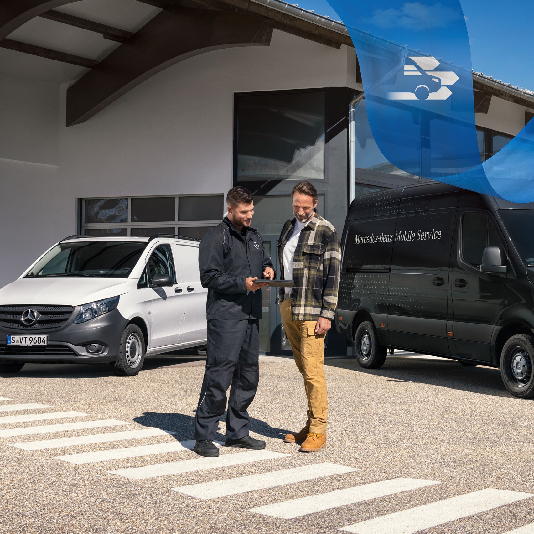 Két férfi beszélget egy fehér Mercedes-Benz Vito és egy fekete Mercedes-Benz Sprinter előtt.