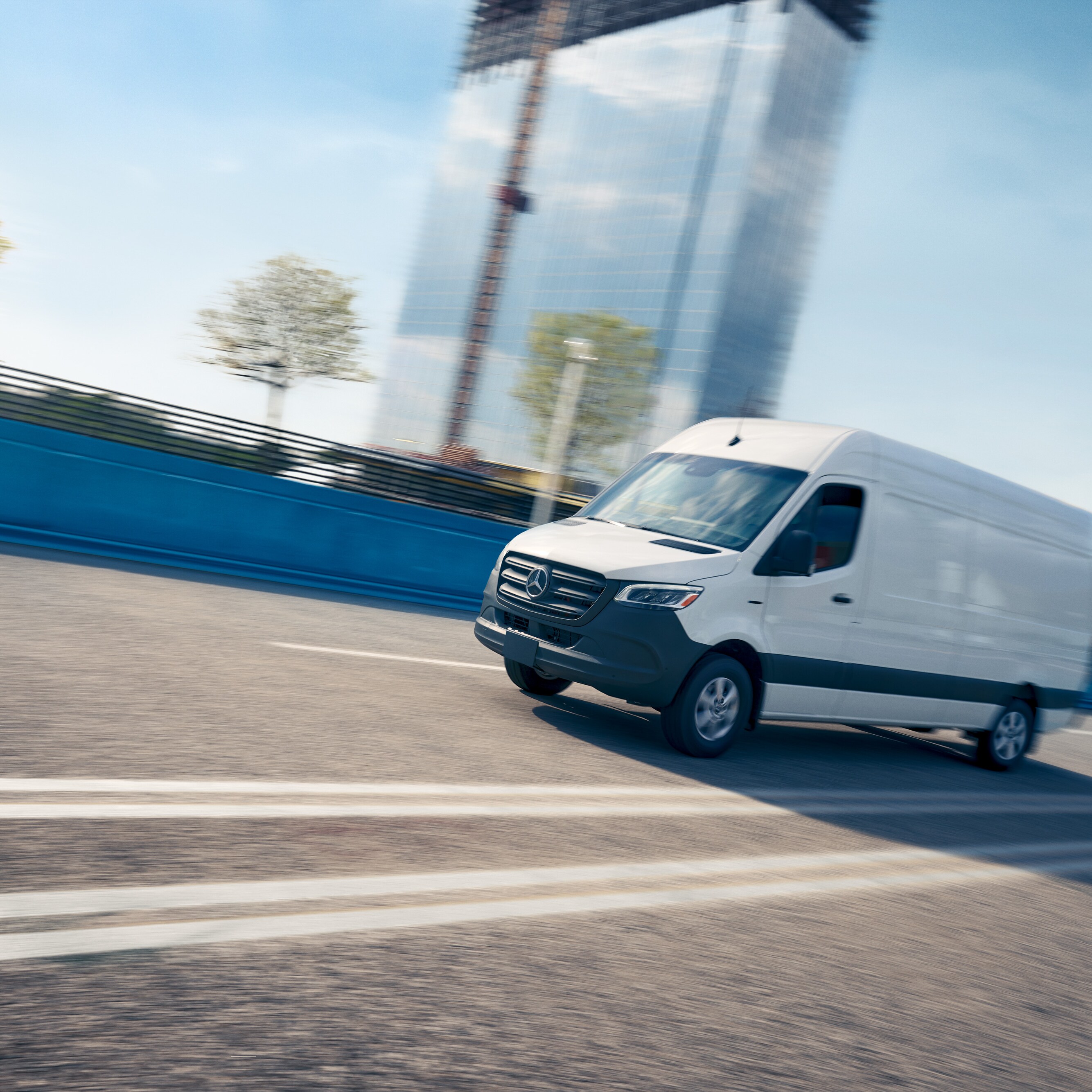 Fehér kishaszonjármű halad az úton, reklámozva a Mercedes-Benz Service App alkalmazást, amely online időpontfoglalást tesz lehetővé.