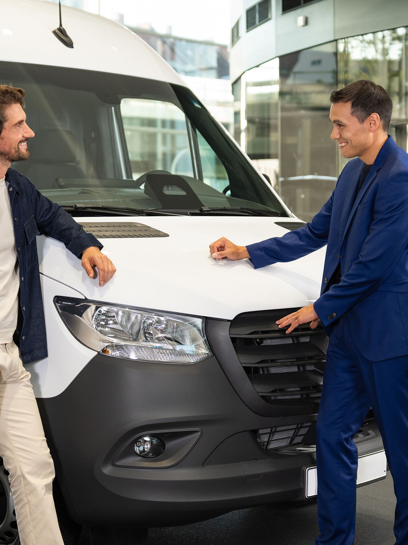 Egy férfi beszél a Mercedes-Benz márkakereskedővel a fehér eSprinter Van-ről